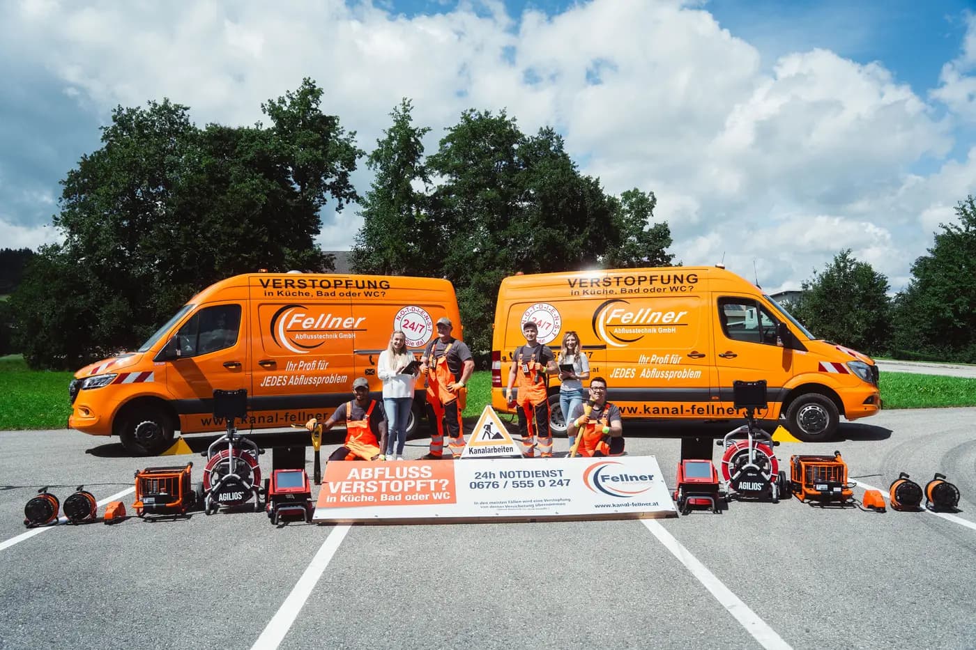 Team der Fellner Abflusstechnik GmbH vor den orangen Einsatzfahrzeugen